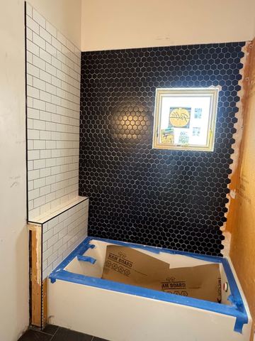 Black hex tile accent wall in a new shower