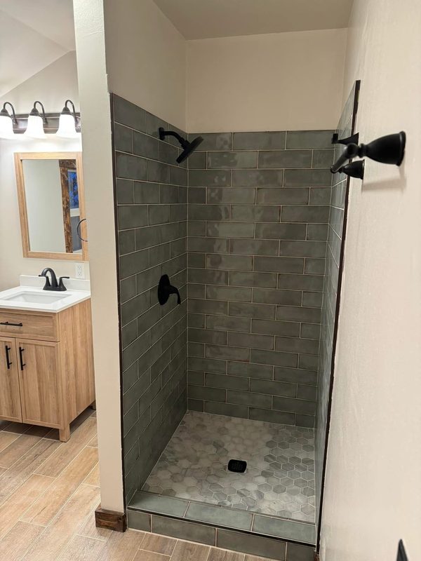 Walk-in shower in glazed subway tile with a hex tile floor