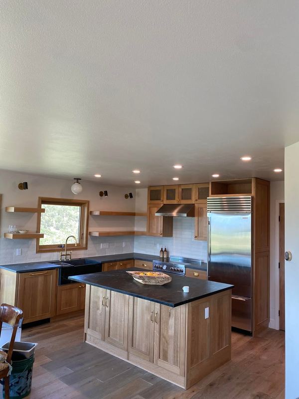 Natural wood cabinets with stone counters and open shelving